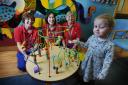 Oxford Children's Hospital is 10-years-old this year. .Three-year-old Maiya Clarke in the outpatients department with, L to R, senior health play specialists Sonia Dugmore and Becky Clifford, and health play specialist Sheila