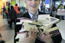 Angus Phillips hands out books to commuters