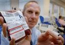 Prof Mike Murphy with a blood bag and a barcode wristband used to ensure patients get the right type of blood