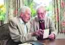 Stan Rhymes, 90, and Bill Rhymes, 92, look at documents and photographs from the run-up to D-Day
