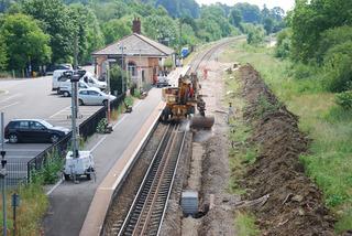 An excavator covers newly-laid drains in the trackbed at Charlbury station during preparatory work for the redoubling project on Sunday, June 27, 2010. The station will get an extra set of rails and a new platform on the right