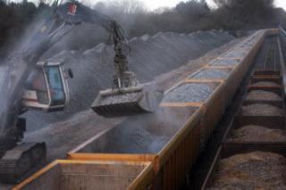 Unloading stone ballast for railway tracks from a train at Network Rail's Hinksey Sidings engineering depot in Oxford on December 17, 2010