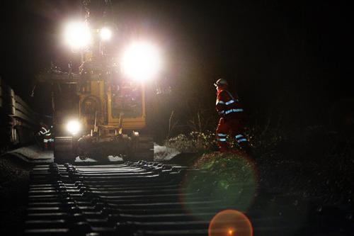 Spotlights on a road-rail excavator light up newly-laid sleepers at Dorn cutting, in Gloucestershire