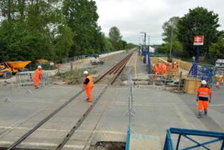 Contractors on the level crossing at Ascott-under-Wychwood on Wednesday, May 18, 2011, with the village station's new platform taking shape on the left.