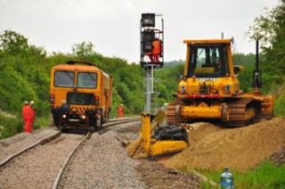A tamping unit packs stone chippings around sleepers to support track close to the Cornbury Park bridge at Charlbury