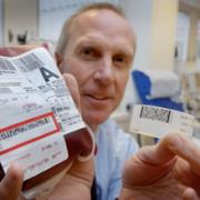 Prof Mike Murphy with a blood bag and a barcode wristband used to ensure patients get the right type of blood