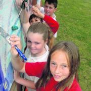 Alicia Higgs, 11, front, and Amberley Castle, 11, behind her, work on the mural