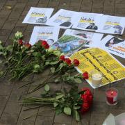 Flowers on the ground next to photographs of people allegedly killed by the government in Iran; at the protest in Bonn Square, Oxford, on Tuesday following the death of Mahsa Amini