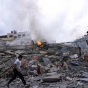 Palestinians walk amid the rubble following Israeli airstrikes in Gaza City in October