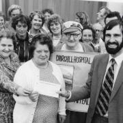 Mary Haines, in the white cardigan, hands her cheque to Churchill Hospital house governor John Hunt in 1982