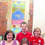 Brigade members who will be making a stained glass window for Wallingford Methodist Church, pictured in front of one that was made earlier – from left Abigail Tarling 15, Chris Tarling 13, Finley Young, nine, and Sophie Walsh 11