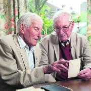 Stan Rhymes, 90, and Bill Rhymes, 92, look at documents and photographs from the run-up to D-Day