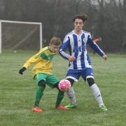 Kennington's Harvey Williams shield the ball from St Edmunds' Ethan Hoskin during their Under 13 KO Cup clash