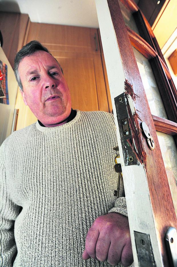 DISMAY: Richard Arrandale with the back door which had been forced open by burglars