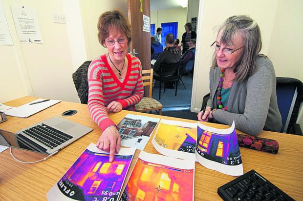 Oxford Mail: Rose Hill and Iffley Low Carbon Group volunteer Caroline Mason, left, show Lorna Bourdeaux thermal imaging pictures  Picture: OX65361 Andrew Walmsley