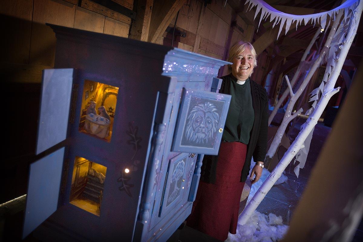 Rector of Dorchester Abbey Sue Booys opens the door to Narnia at an exhibition