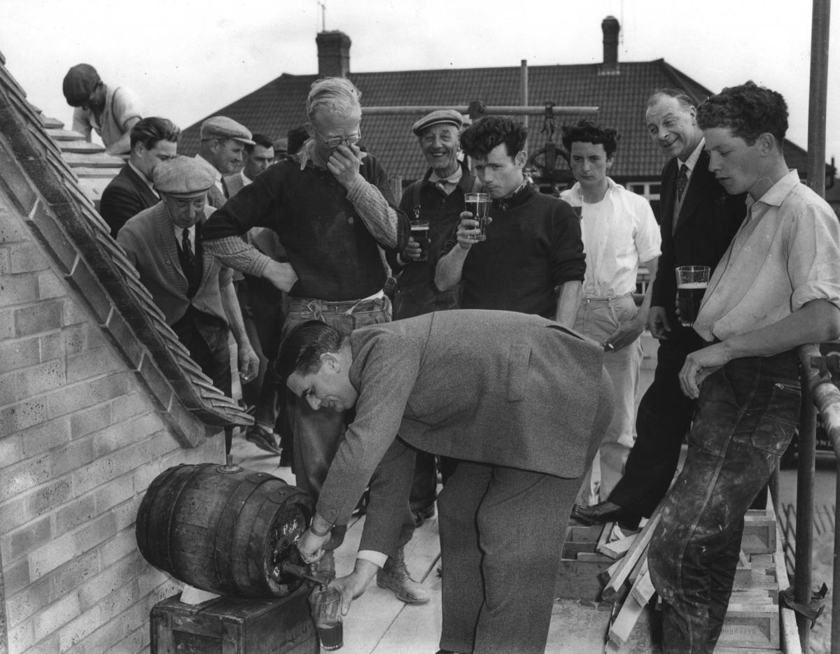 Topping out ceremony on the Fairview Inn,on the pubs completion 1959. Pictured Mr G L Hardwick (District Manager of Simonds) filling glasses for the workmen.