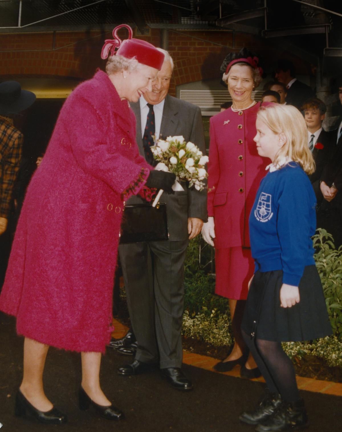 The Queen receives a posy from Hannah Gibbons, nine, during her visit to Radley College, near Abingdon, in November 1997.