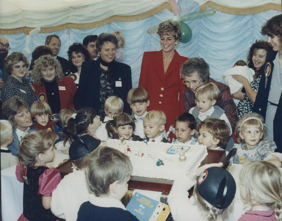 Princess Diana watching children blow out the candles on the birthday cake of the National Meningitis Trust in 1991.