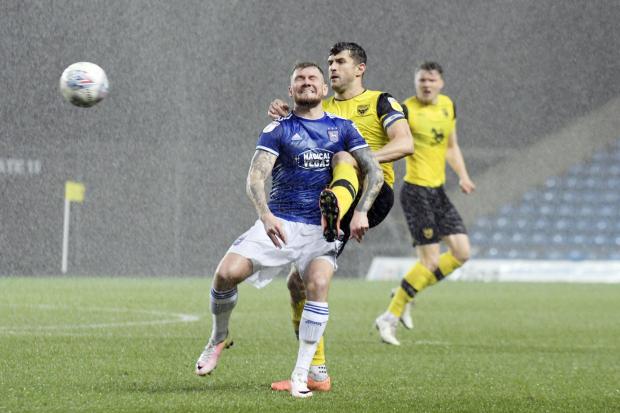 John Mousinho defends his ground against James Norwood in a clash at the Kassam Stadium in January 2020. Picture: David Fleming