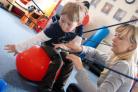 Oscar Scott Towers, five, on the Spider with Footsteps physiotherapist Gosia Swietlik