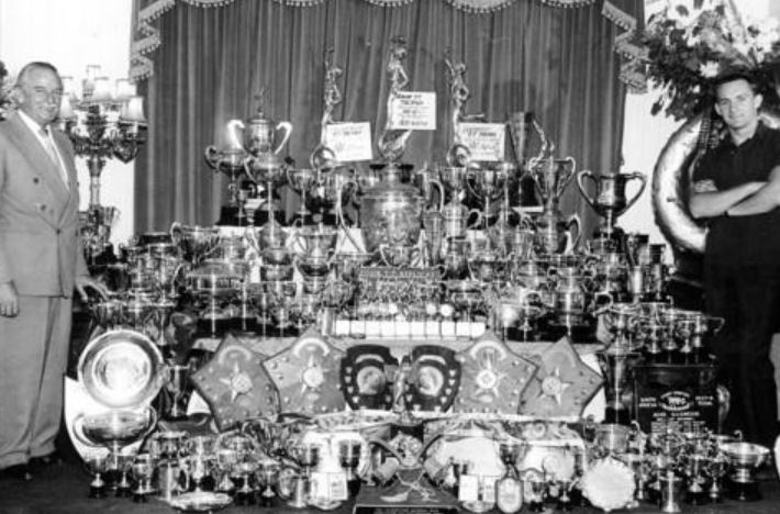 Mike, right, with his father Stanley and the 250 trophies he had won by 1961