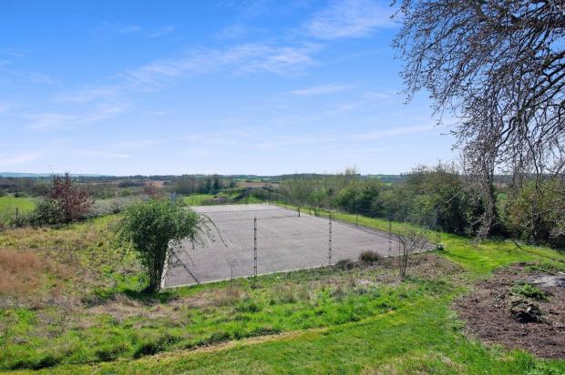 Oxford Mail: The cottage has an outdoor tennis court. Picture: Strutt & Parker