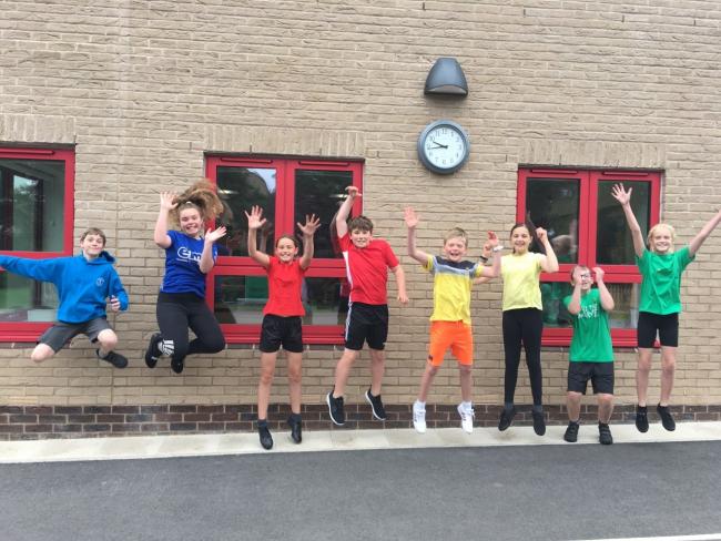 Students jump for joy outside the new building at West Witney Primary School. Picture: Liam Rice