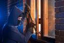 Burglar using crowbar to break into a house at night. Picture: Newsquest