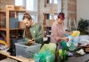 Two women sorting through recycling. Credit: Canva