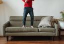 A child jumping on the sofa