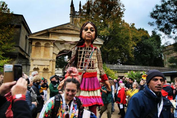 Oxford Mail: Little Amal meets Alice from The Story Museum at Oxford Botanic Garden. Picture: Ed Nix