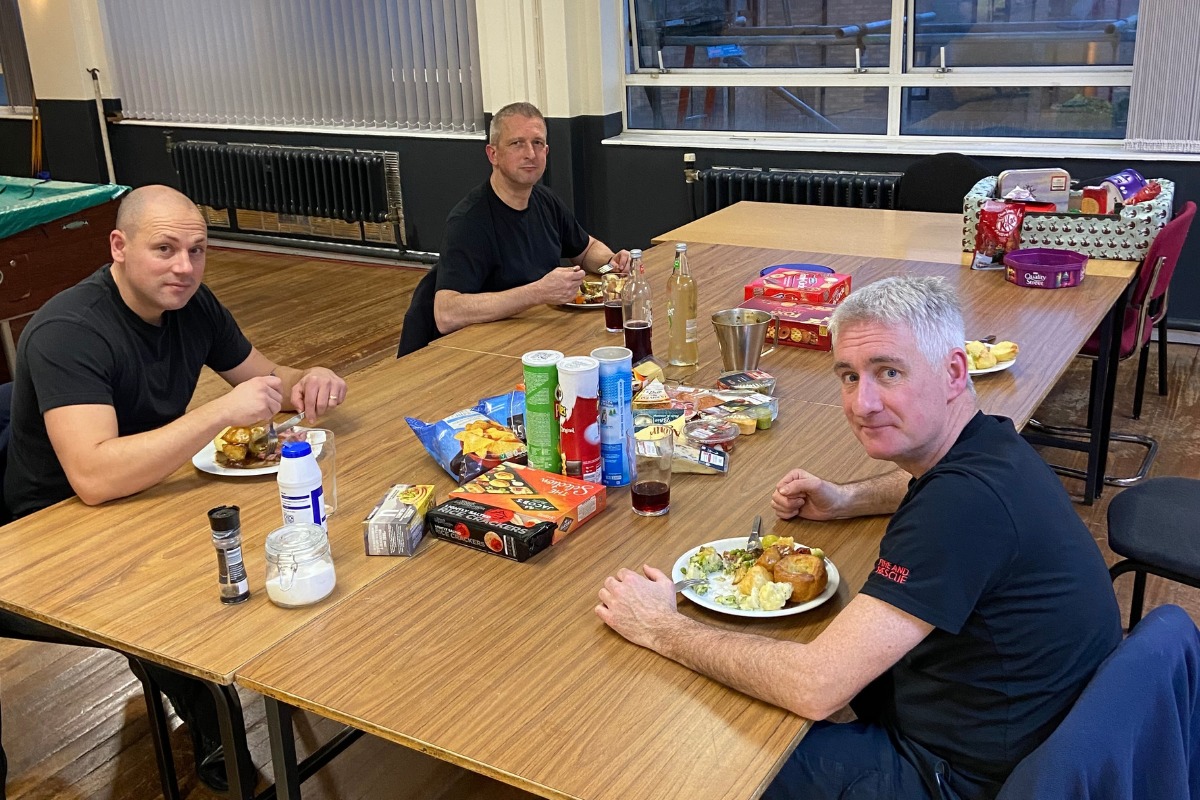 The members of White Watch eat Christmas dinner at Slade Park fire station on Christmas Day, 2021