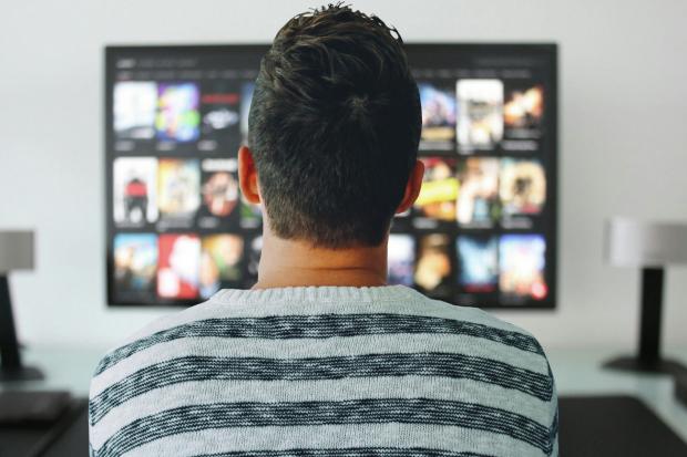 Oxford Mail: A man watching a smart TV. Credit: Canva