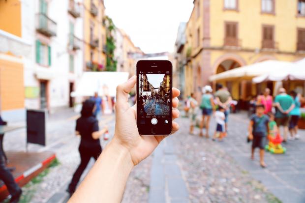 Oxford Mail: A tourist taking a picture of a busy street on their phone. Credit: Canva