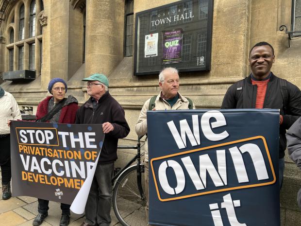 Oxford Mail: Protestors hold signs to protest the sale of publically funded Oxford vaccine centre. 