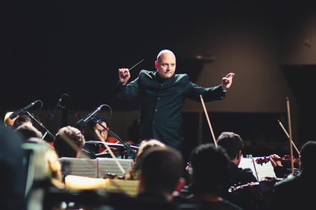Oxford Mail: A conductor leading an orchestra. Credit: Canva