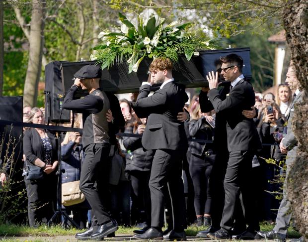 Oxford Mail: Max George (left) and Jay McGuiness of The Wanted (centre) carry the coffin at the funeral of their bandmate Tom Parker. (PA)