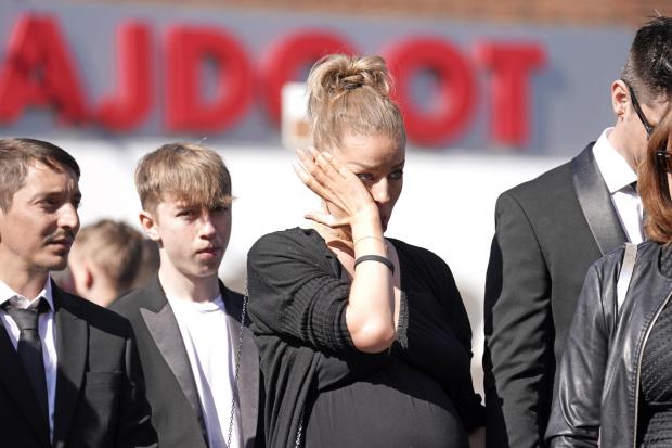Oxford Mail: Mourners watch as the coffin of The Wanted star Tom Parker is carried ahead of his funeral. (PA)
