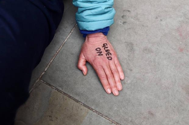 Oxford Mail: Teresa Garlake’s hand glued near the front entrance to the Shell headquarters in London. Picture: Feng Ho