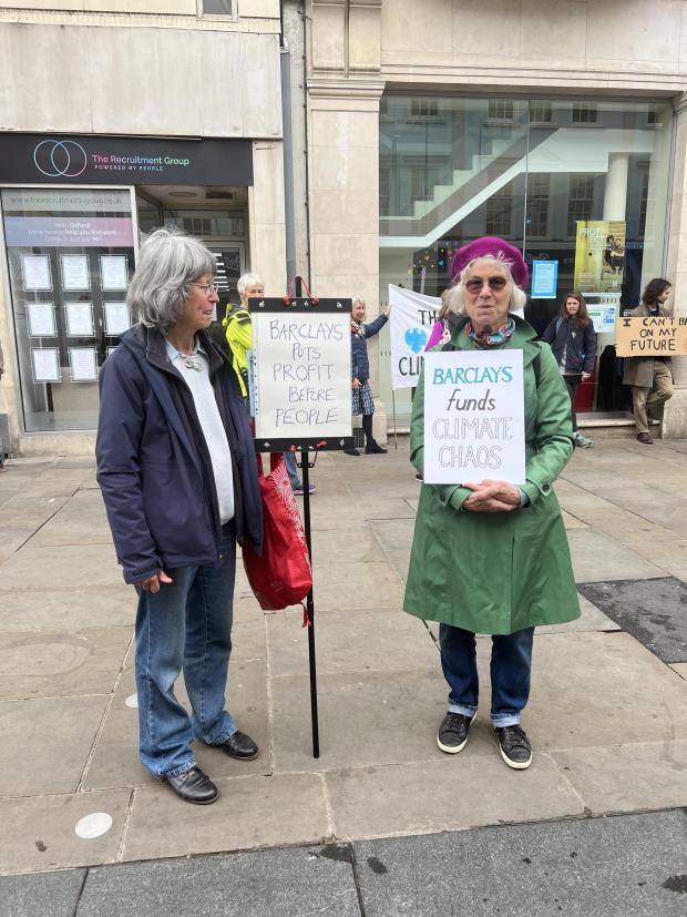 Oxford Mail: Brigid Avison, 69, from Charlbury (left) and Jenny Stanton, 71, from Oxford (right) hold signs and engage passers-by in debate as part of the XR protest.