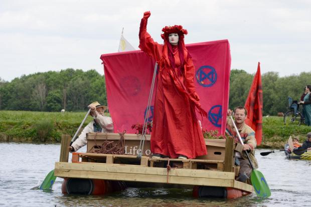Oxford Mail: Haunting figures float down river on recycled raft in protest of sewage spills.