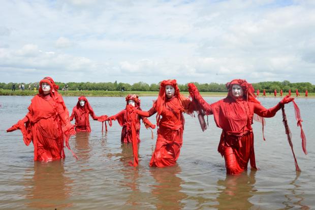 Oxford Mail: Red Rebels join hands in protest of river pollution at Port Meadow. Photo by Rory Carnegie 