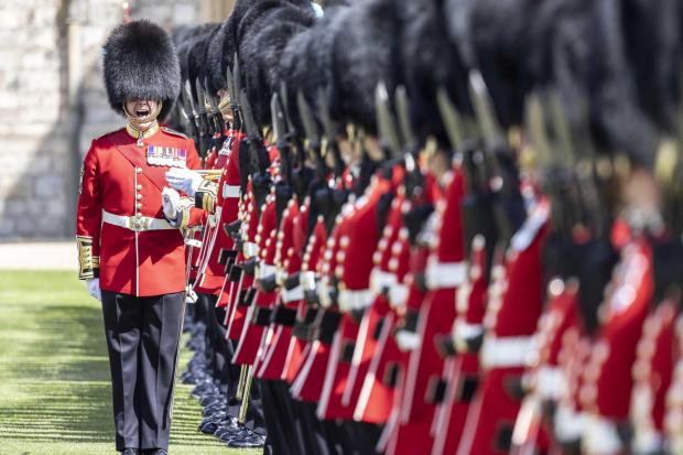 A warrant officer of the 1st battalion Irish guards makes sure the line of guardsmen is straight as the regiment lines up on parade in the Quadrangle of Windsor Castle where their new regimental colours were presented to them by the Duke of Cambridge