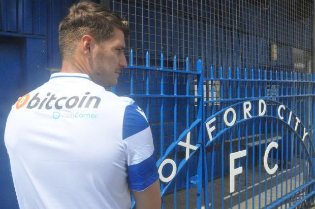 Oxford Mail: Josh Ashby displays the new Oxford City shirt with back of shirt sponsors CoinCorner
