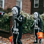 Two skeletons trick or treating. Credit: Canva