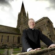 Reverend Canon Toby Wright in front of St Mary's Witney