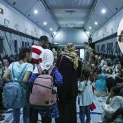 Inside an evacuation flight from Sudan on the left and people leaving a place on the right