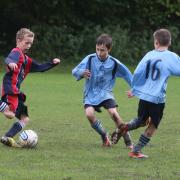 Marston Saints  Under 12s’ Moses Baumann (left) wins this midfield            tussle as Leo           Hudson closes in