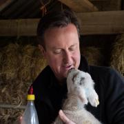 Prime Minister David Cameron helps to feed a newborn lamb at Dean Lane Farm near his Oxfordshire home, having earlier attended an Easter Sunday service in Chadlington with his wife Samantha